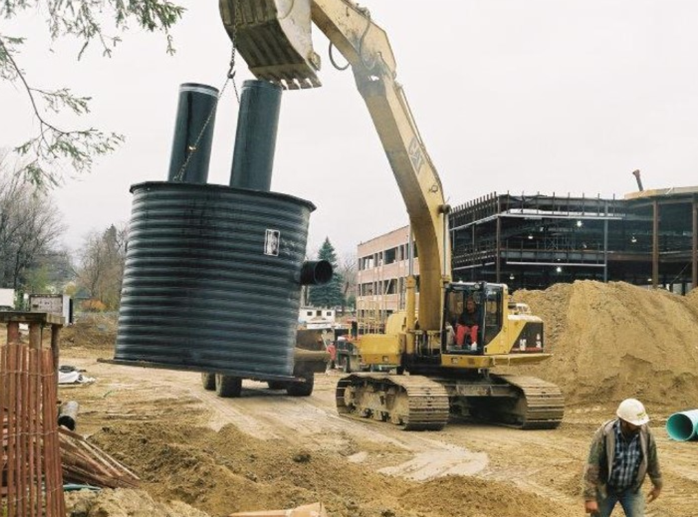 A large construction site with a large metal tank.