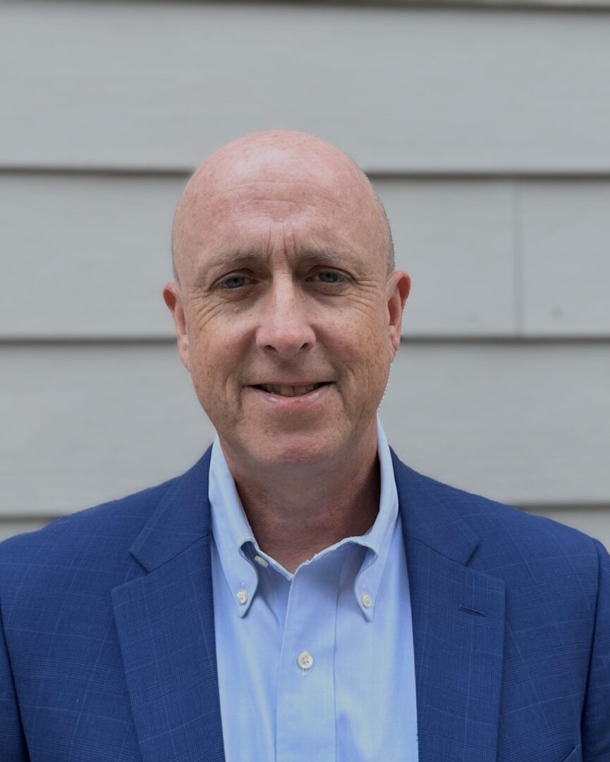 A man in a blue suit and white shirt.