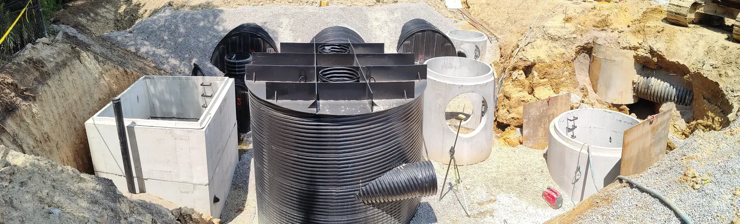 A large black metal barrel sitting on top of concrete.